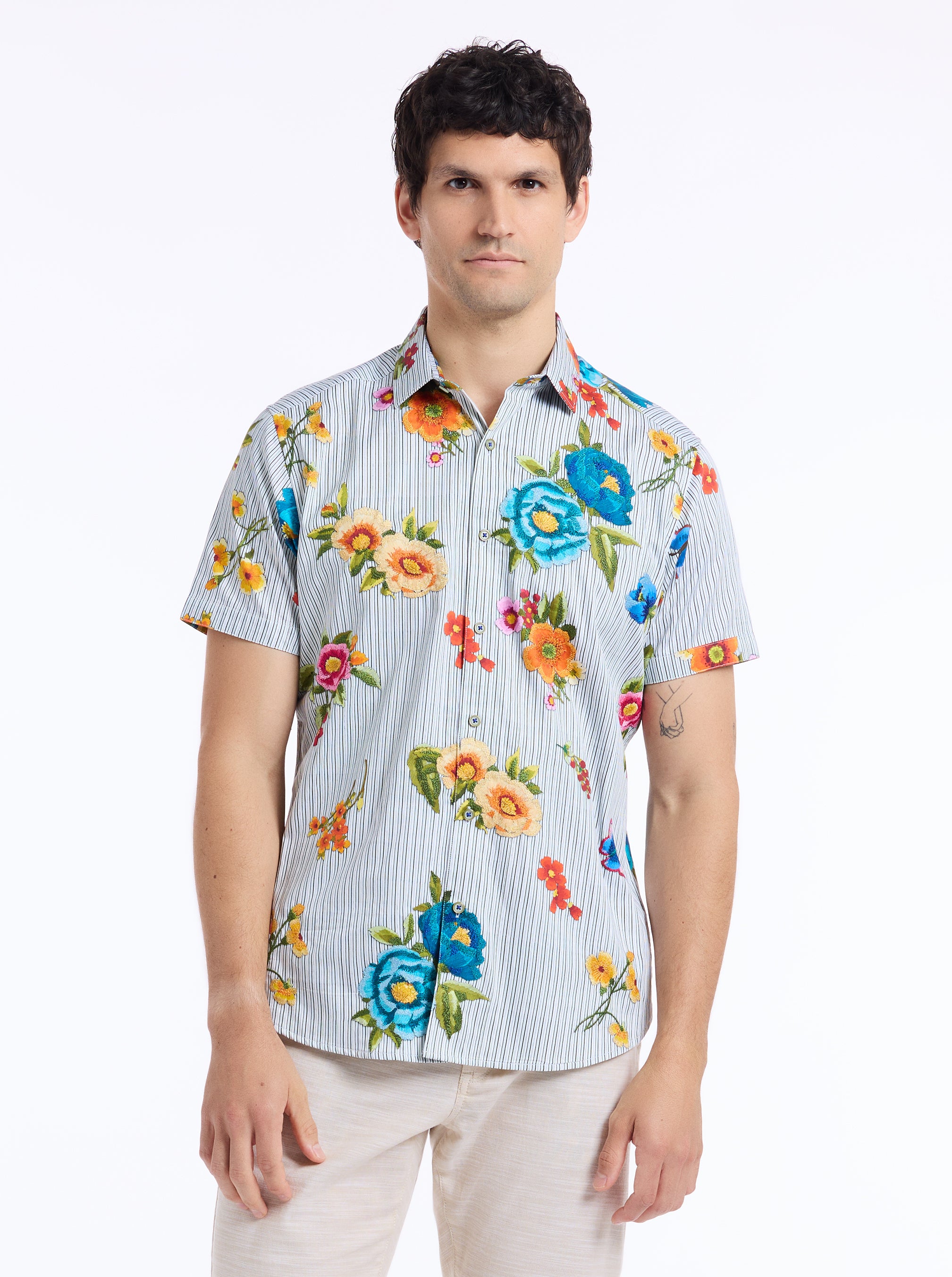 Man wearing a colorful floral shirt with a white background