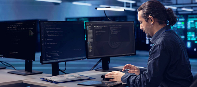 Person working in a NOC, actively engaged in tiered incident management, tracking incidents and system statuses across several monitors